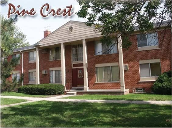 Brick apartment building in warren, michigan with white trim and green lawn, labeled “Pine Crest” at top left