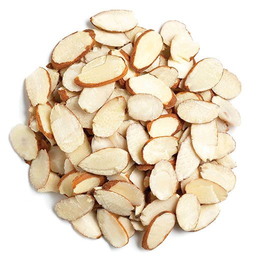 Pile of thinly sliced almonds with brown skins on a white background
