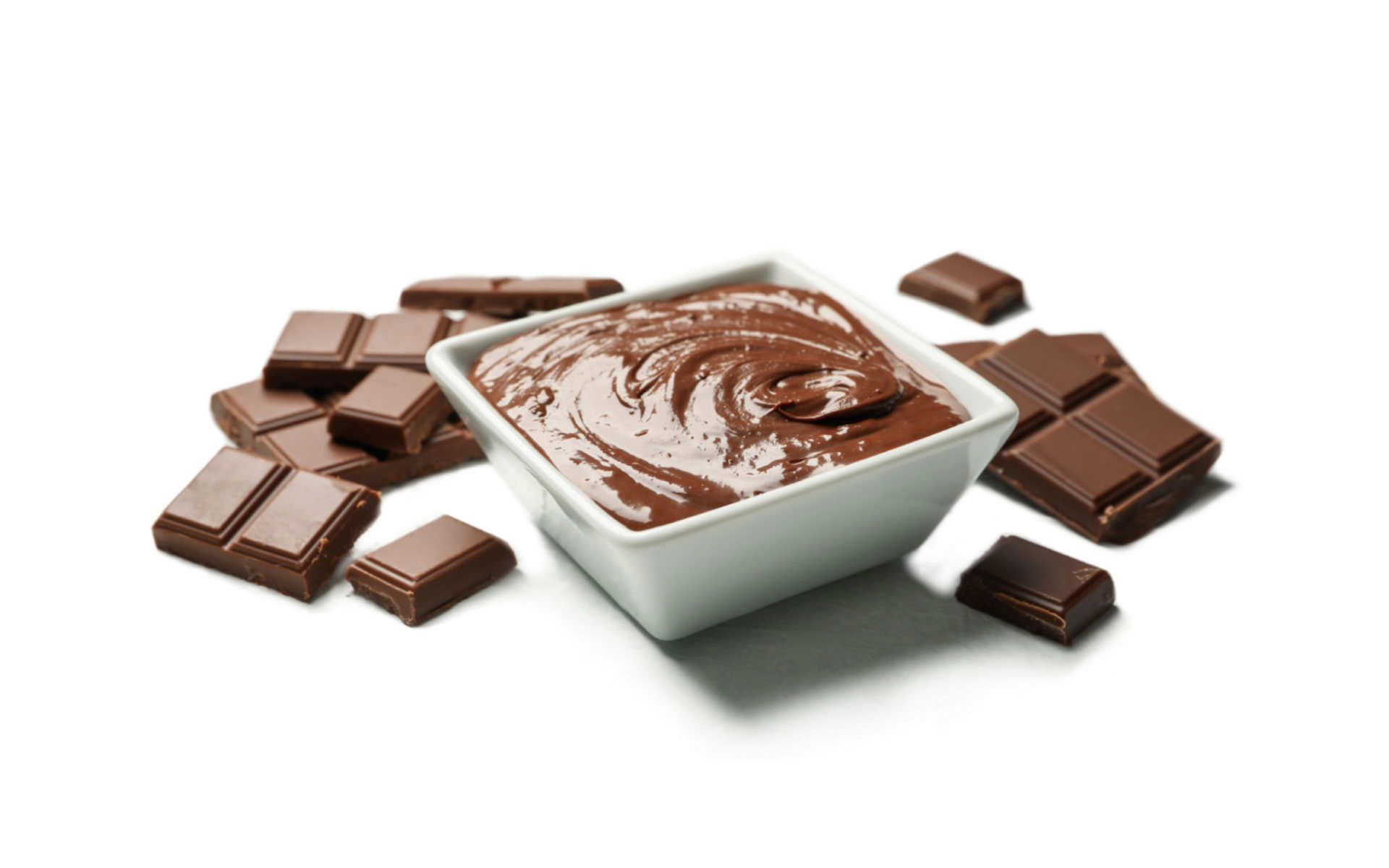 Chocolate dessert in a white bowl surrounded by broken chocolate bars on a white background