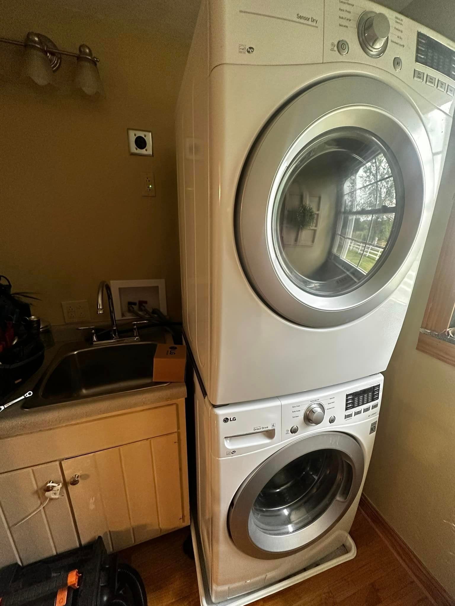 a washer and dryer are stacked on top of each other in a laundry room .