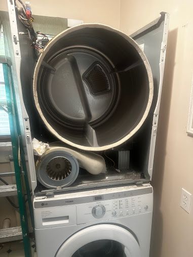 a washer and dryer are stacked on top of each other in a laundry room .