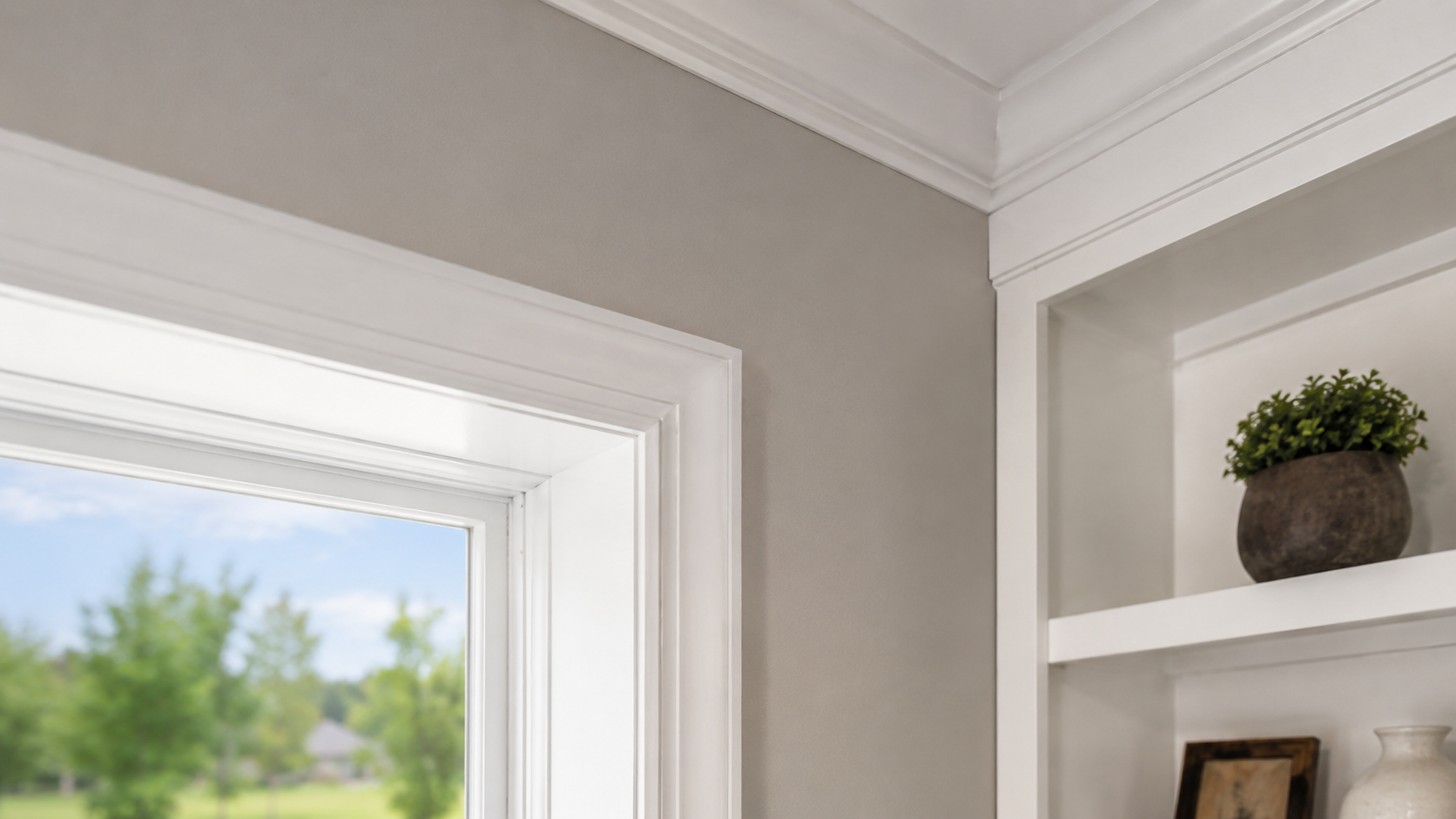 Hand painting white trim around a doorway on a tan exterior wall