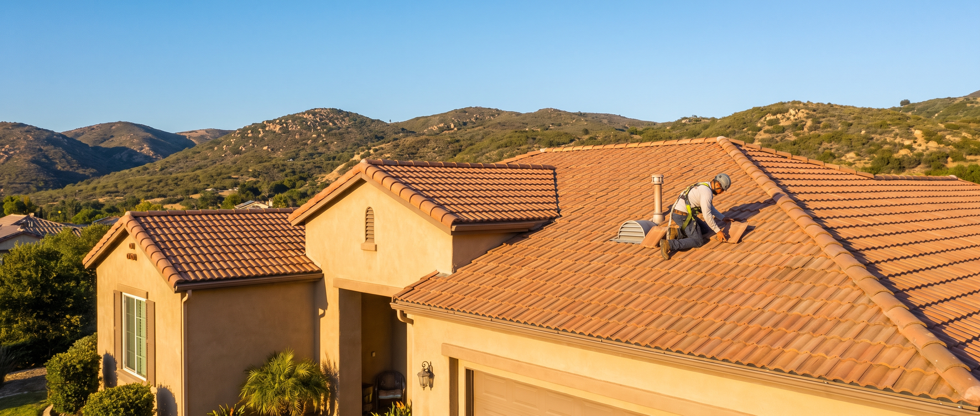 Roofing technician inspecting a concrete tile roof on a Southern California home