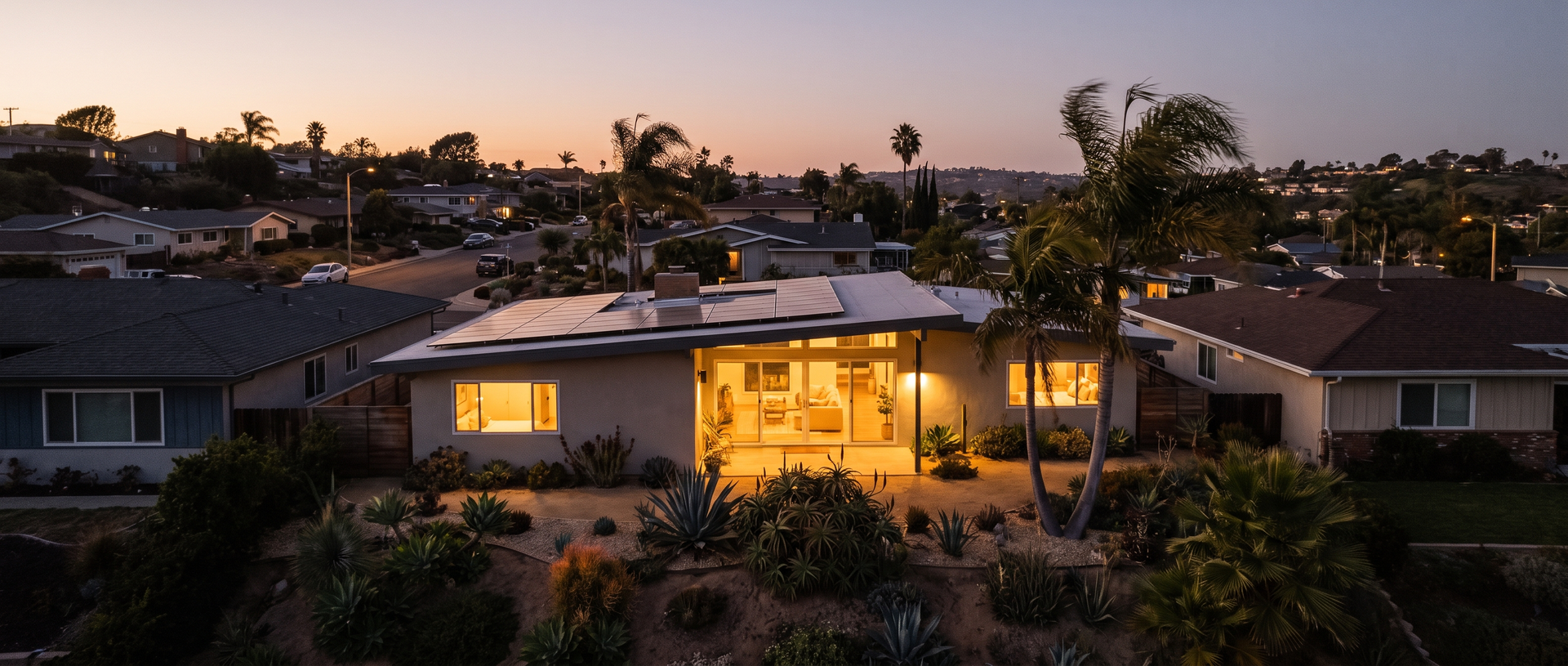 Solar-paneled San Diego home with lights on at dusk during a neighborhood power outage.