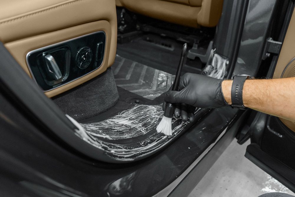 A Person is Cleaning the Inside of a Car With a Brush — Endrust (Coffs Harbour) in Coffs Harbour, NSW
