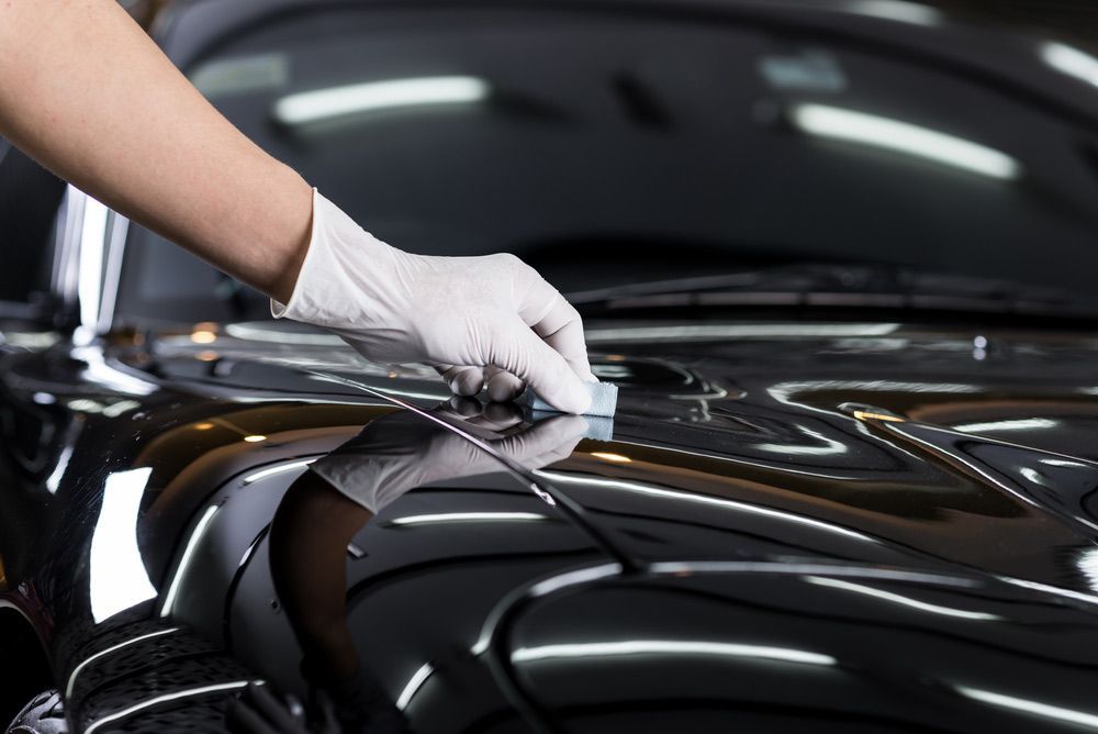 A Person is Polishing the Hood of a Black Car — Endrust (Coffs Harbour) in Coffs Harbour, NSW
