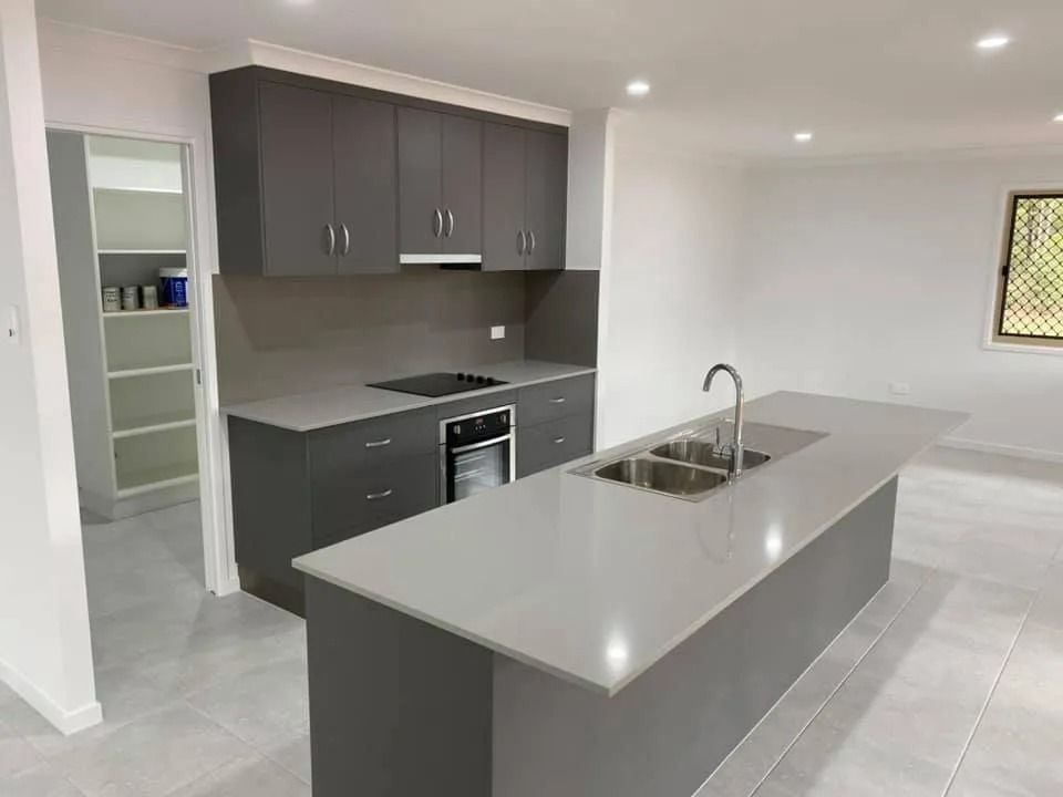 Modern Kitchen with Dark Gray Cabinets, Light Countertops — Country to Coast Homes In Gregory River, QLD