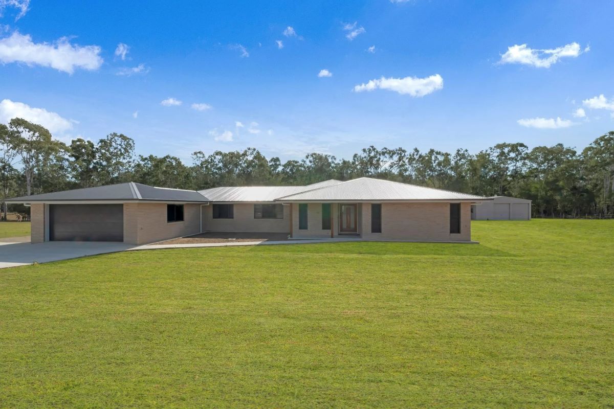 A Single-Story Brick House with A Garage on A Large Grassy Lot — Country to Coast Homes In Gregory River, QLD