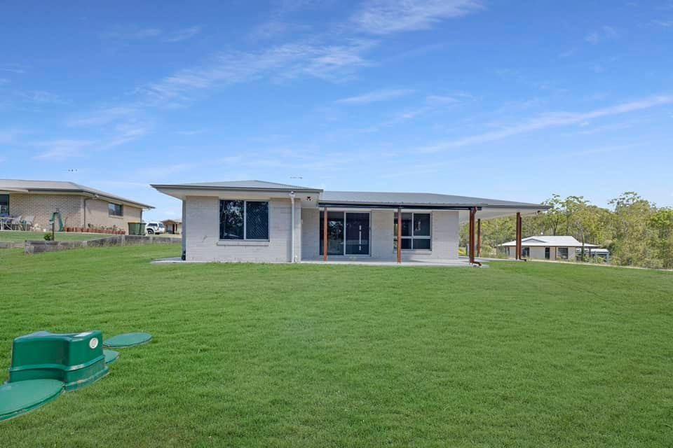A Single-Story House with A Light Gray Exterior and A Large Grassy Yard — Country to Coast Homes In Gregory River, QLD