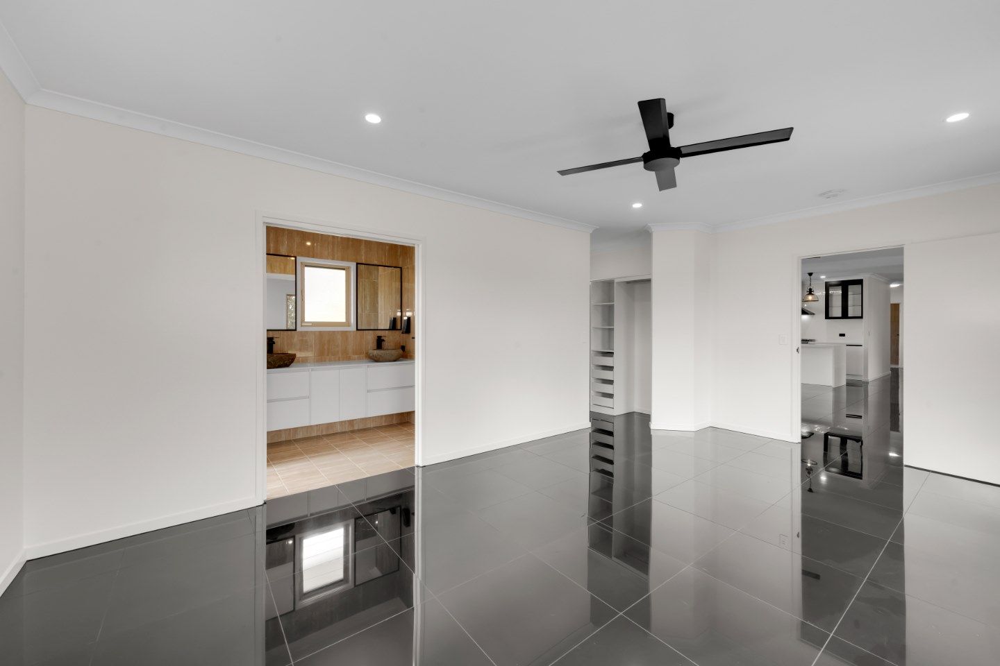 Empty Room with Glossy Black Floor, White Walls, and A Black Ceiling Fan — Country to Coast Homes In Gregory River, QLD