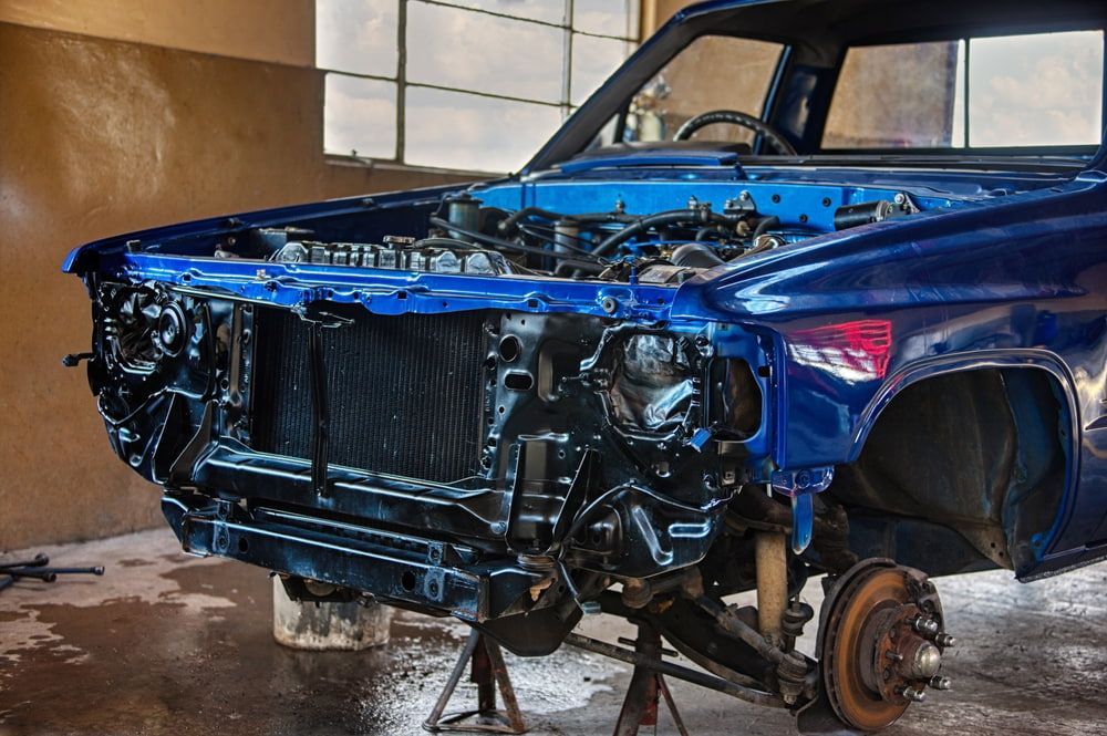 A Blue Car Is Being Worked on In a Garage — Wyong Radiator Repairs in Tuggerah, NSW