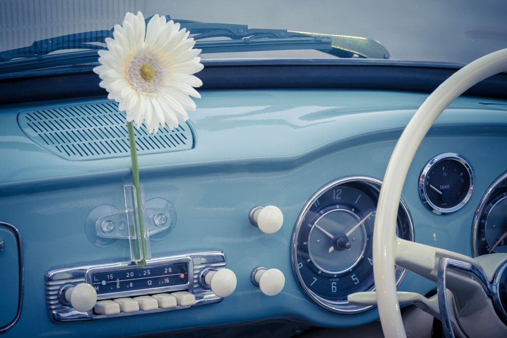 A White Flower Is in A Vase on The Dashboard of A Blue Car — Wyong Radiator Repairs in Tuggerah, NSW