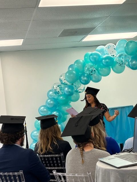 A woman is giving a speech at a graduation ceremony at KCMI.