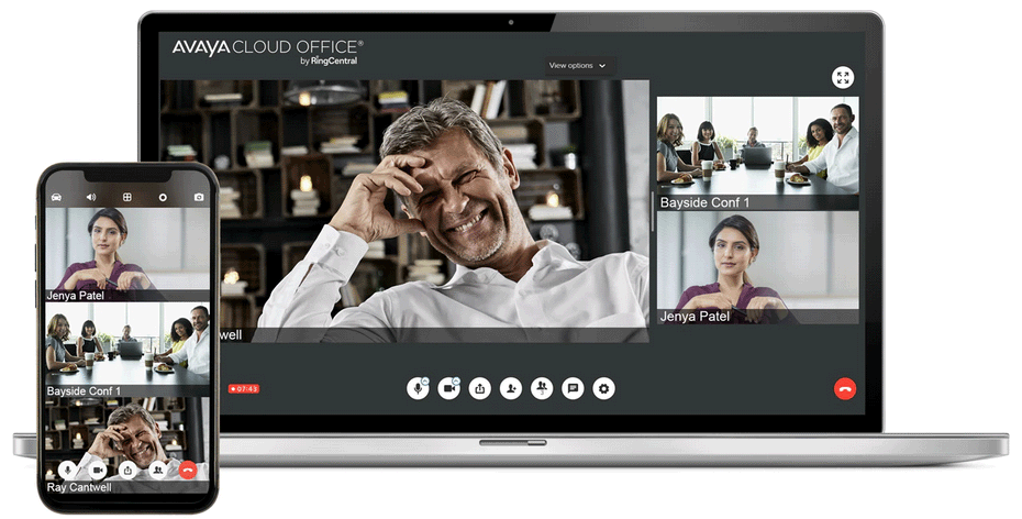Video conference on laptop and phone; man smiles, other participants in windows.