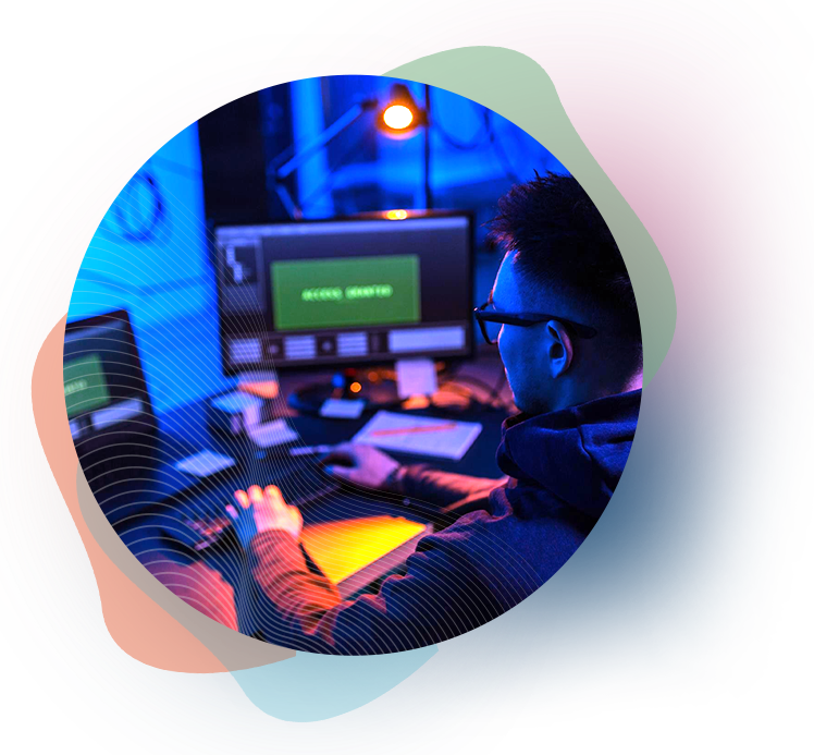 Man at computer with green monitor in a room with blue and orange lights, possibly hacking.