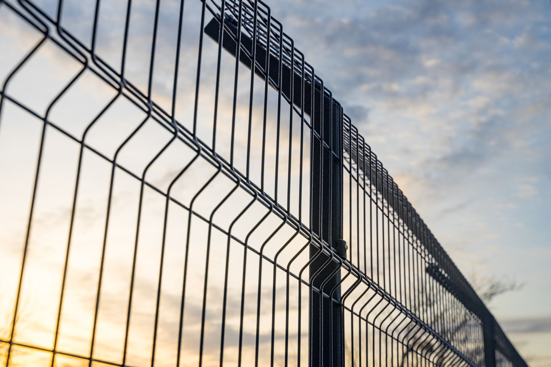 Steel grating fence made with wire on a blue sky background.