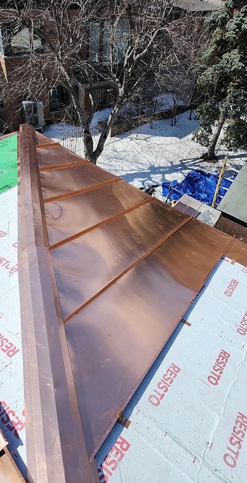 A copper roof is being installed on a house.