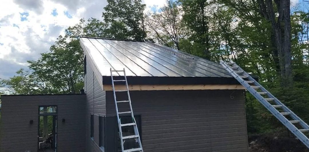 A ladder is sitting on the roof of a house.