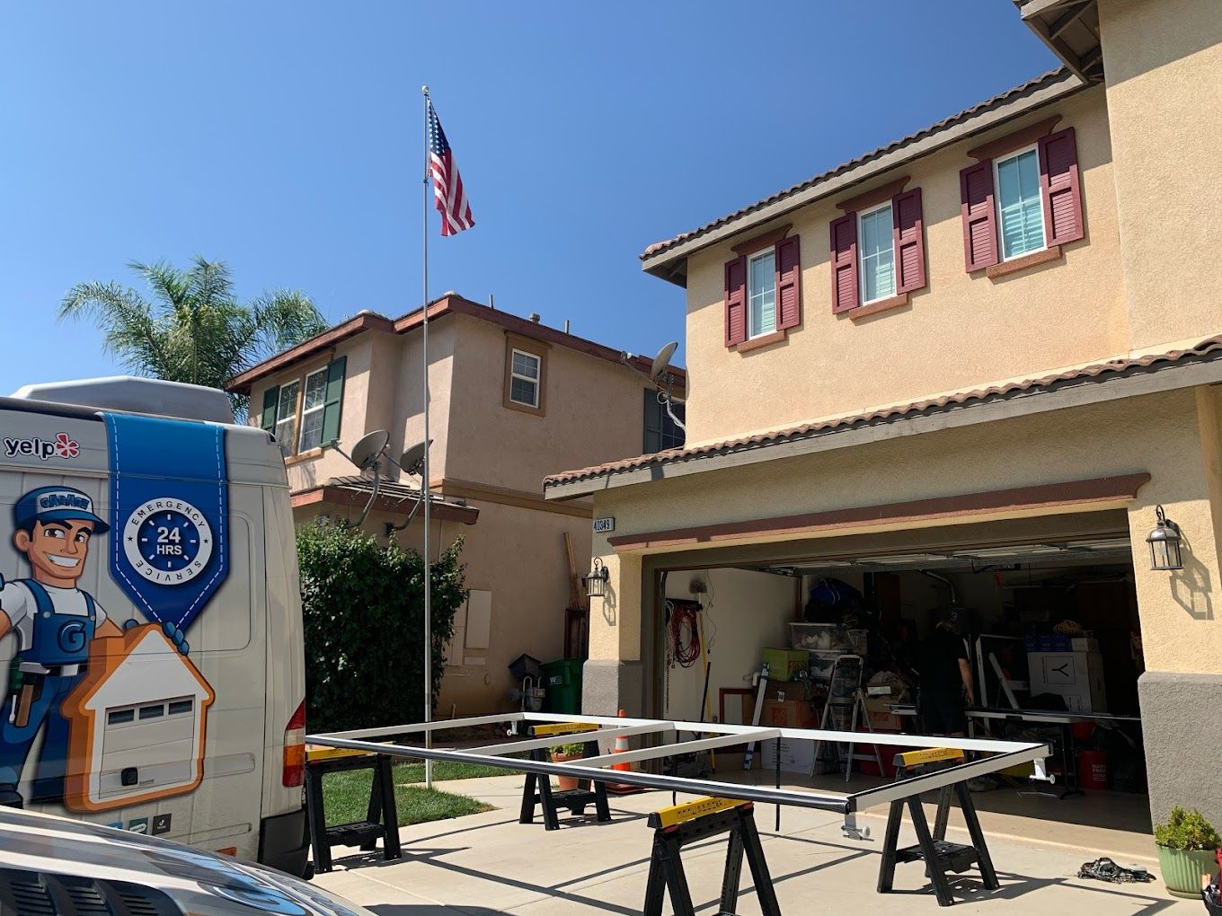 A truck with a man on it is parked in front of a house.