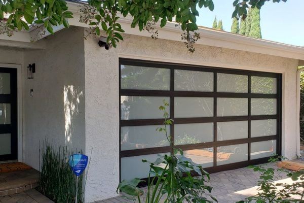 A white house with a large glass garage door.