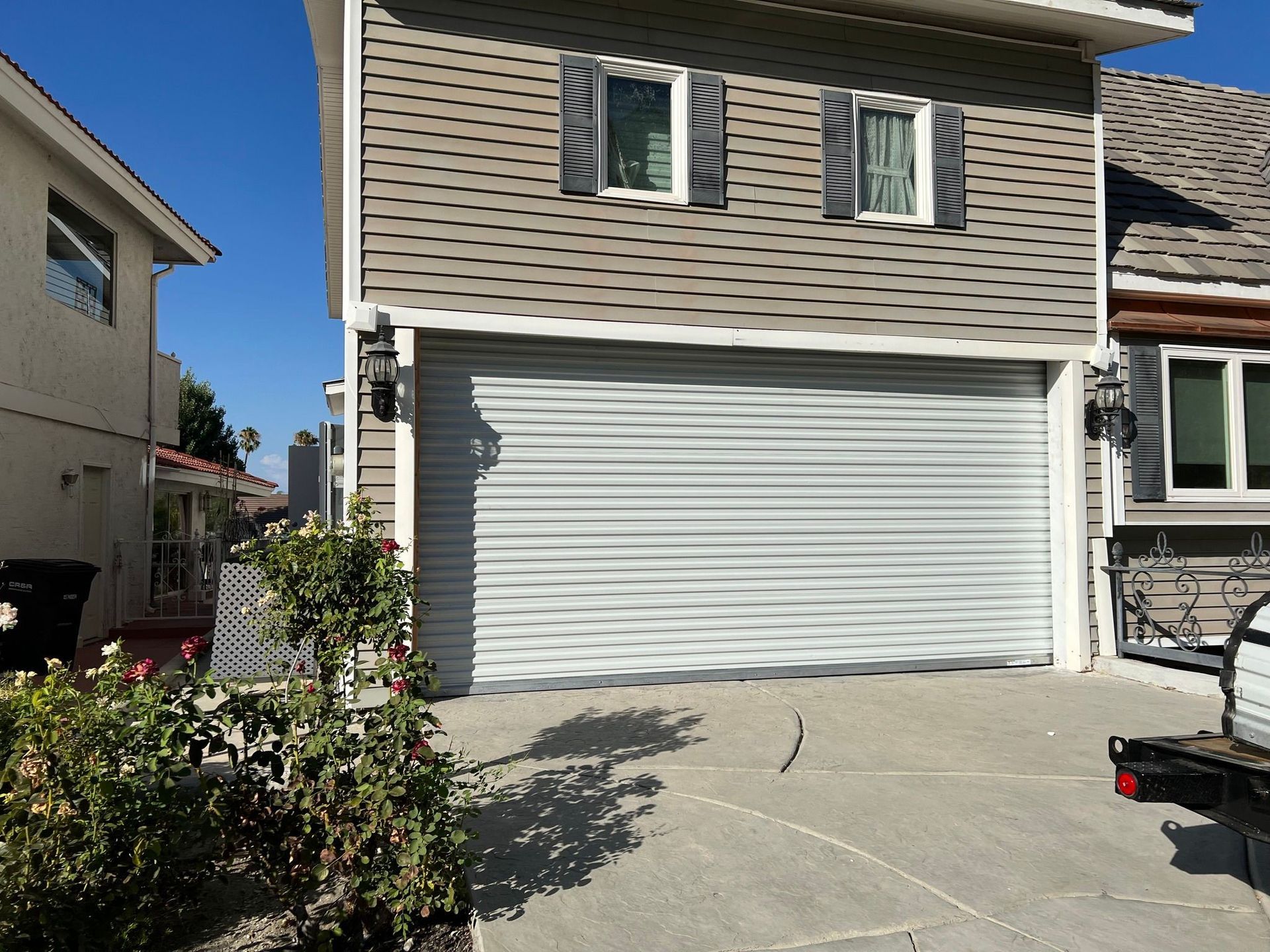 A white truck is parked in front of a house with a garage door