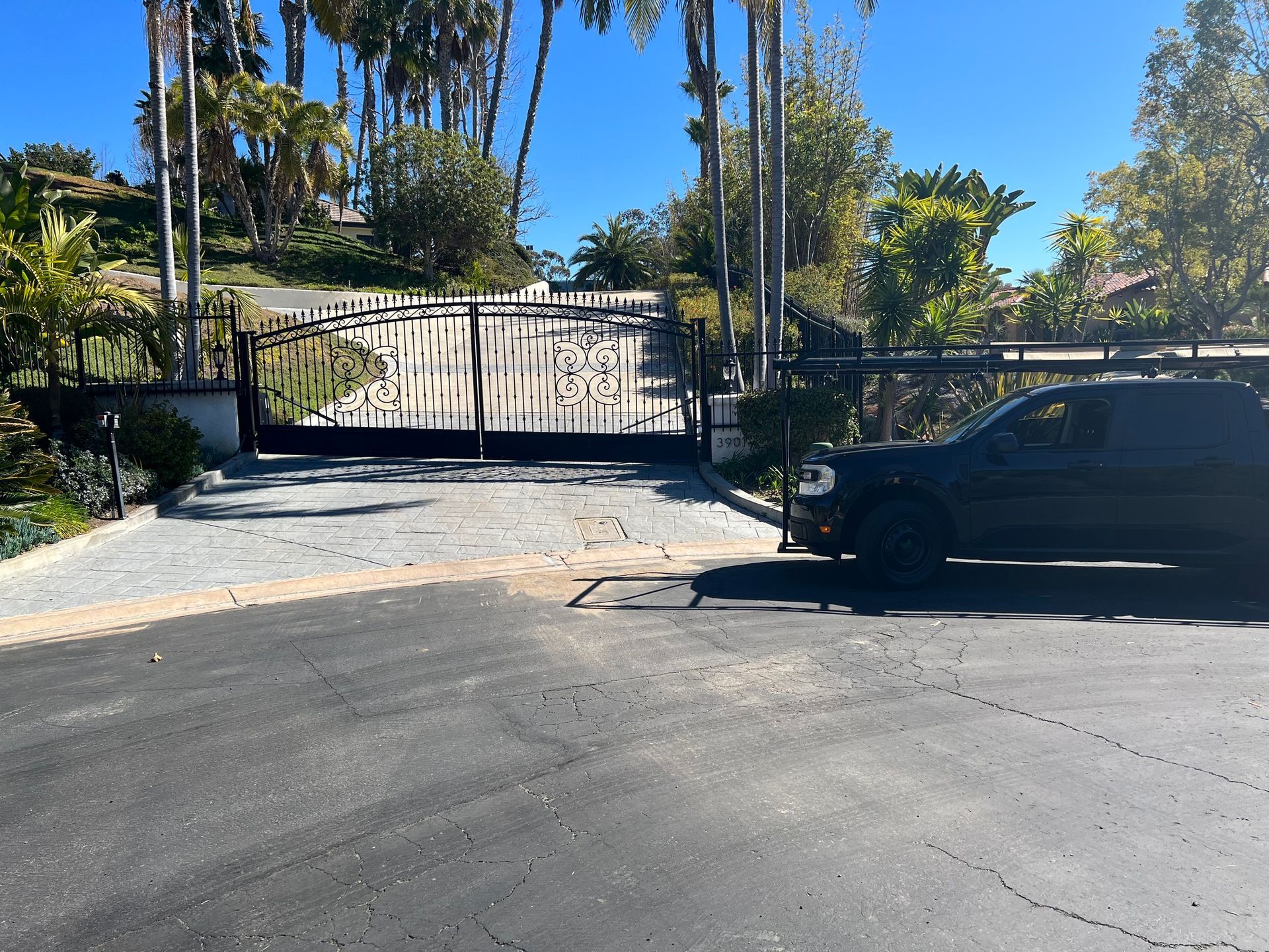 A black suv is parked in front of a gate
