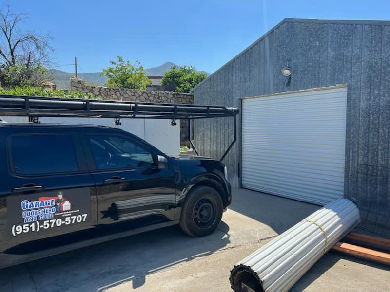 A black van is parked in front of a garage door.