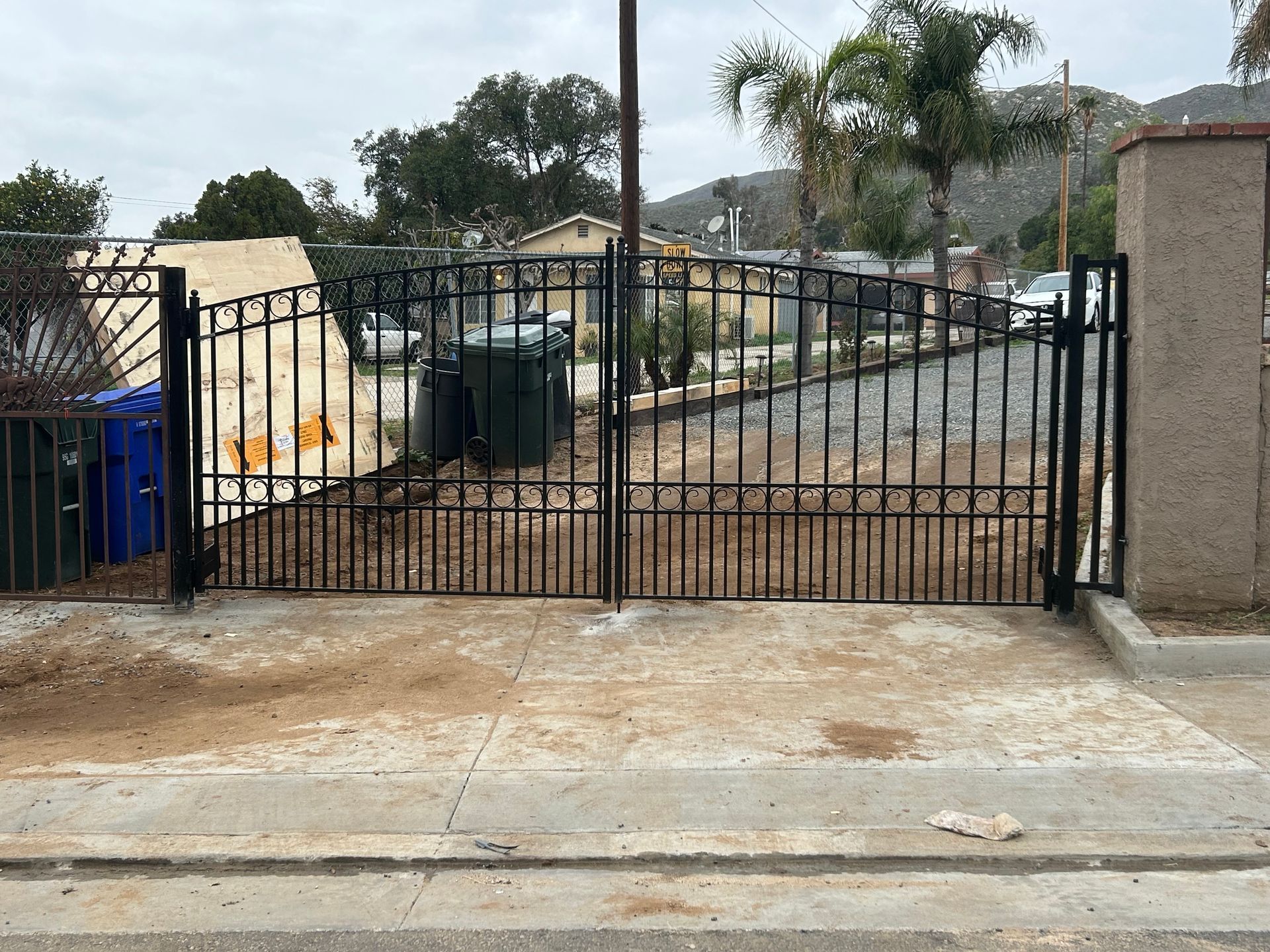 A wrought iron gate is sitting on the side of a road.