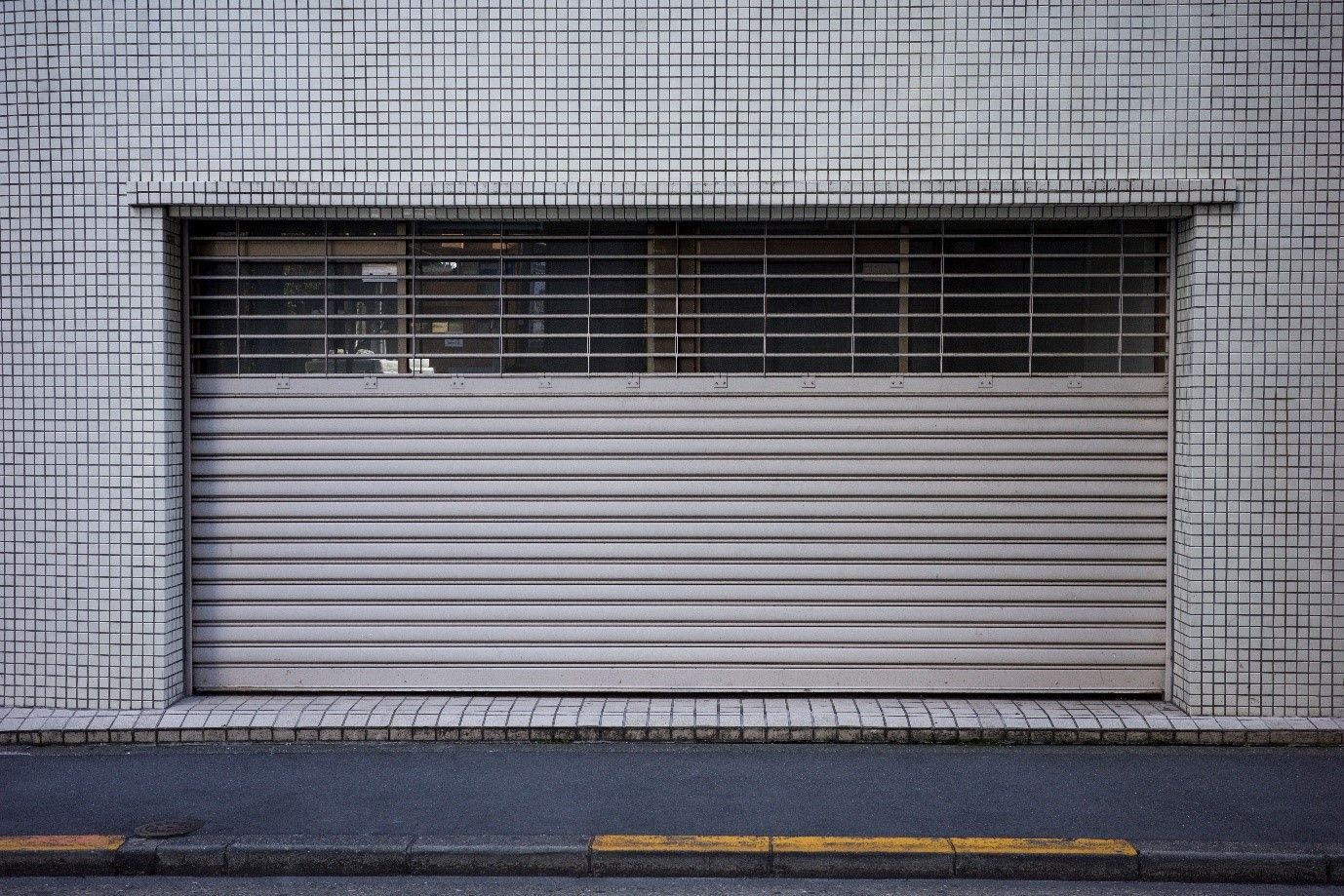 A garage door is closed on the side of a building.