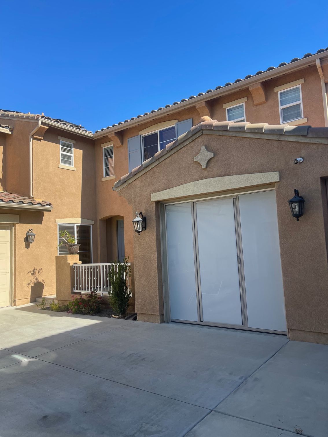 A large brown house with a white garage door