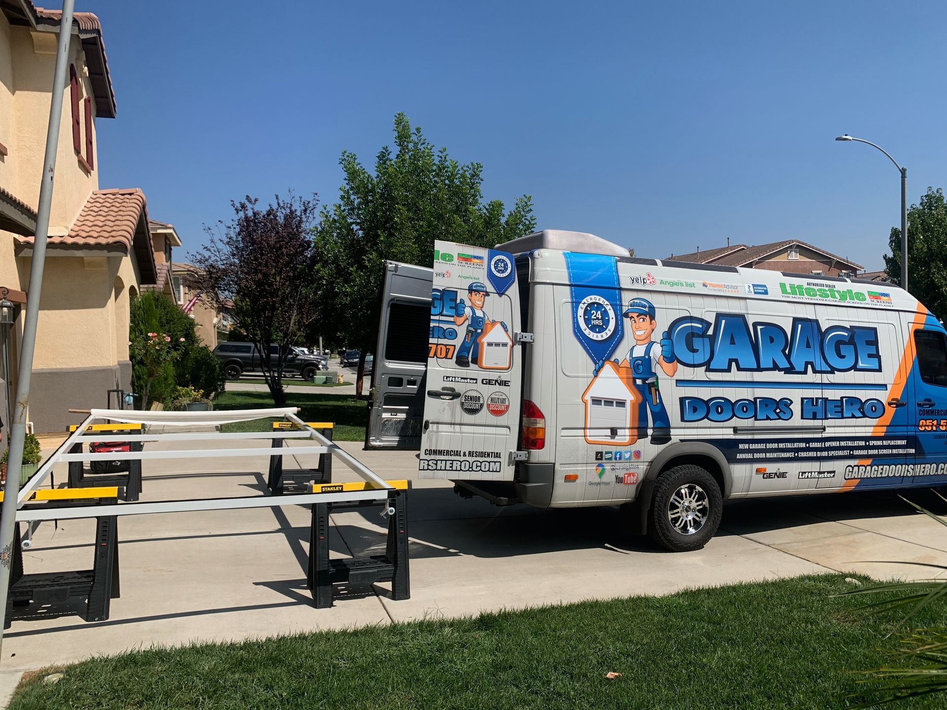 A garage truck is parked in front of a house.