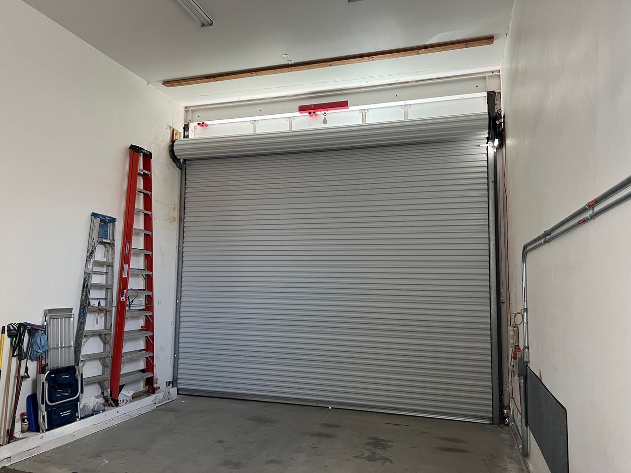 A garage with a garage door and a ladder.