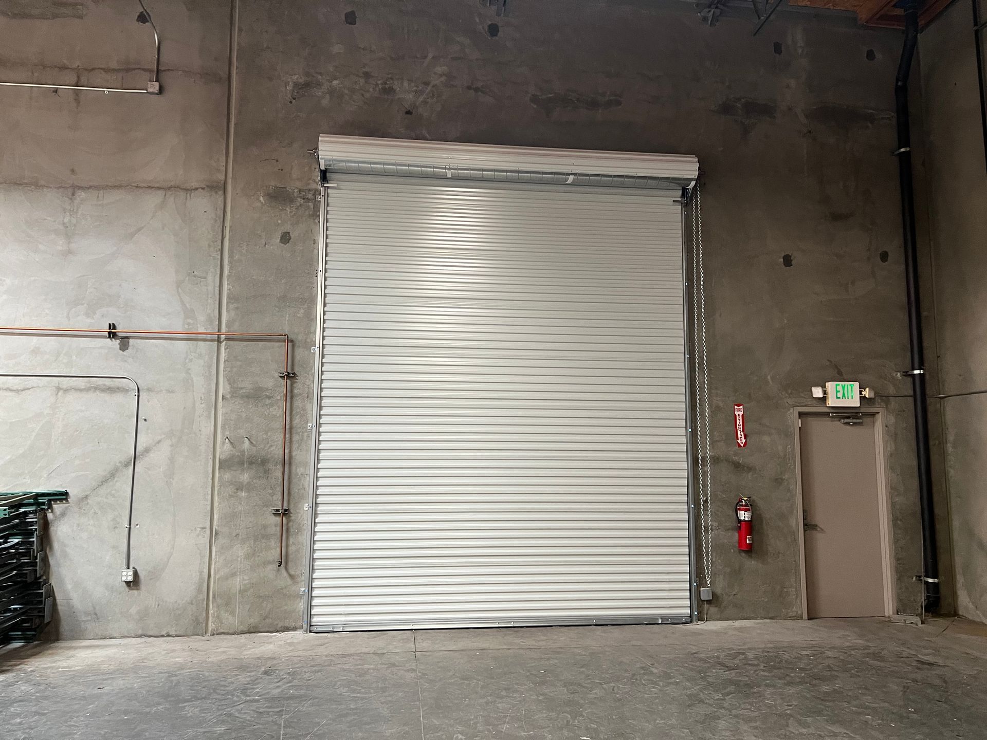 A large white garage door is open in a warehouse