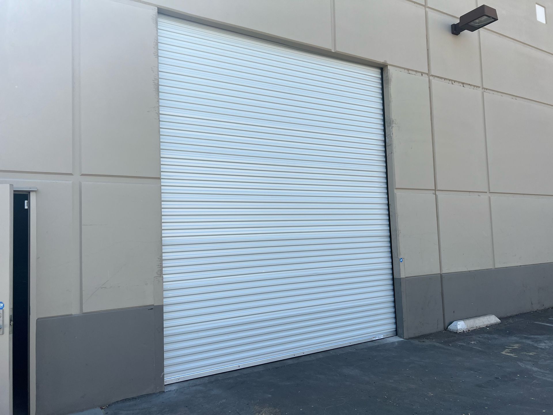 A white garage door is sitting on the side of a building.