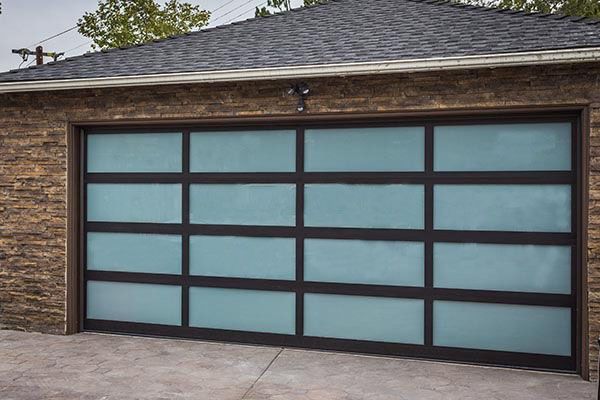A garage door with a lot of windows and a brick wall.