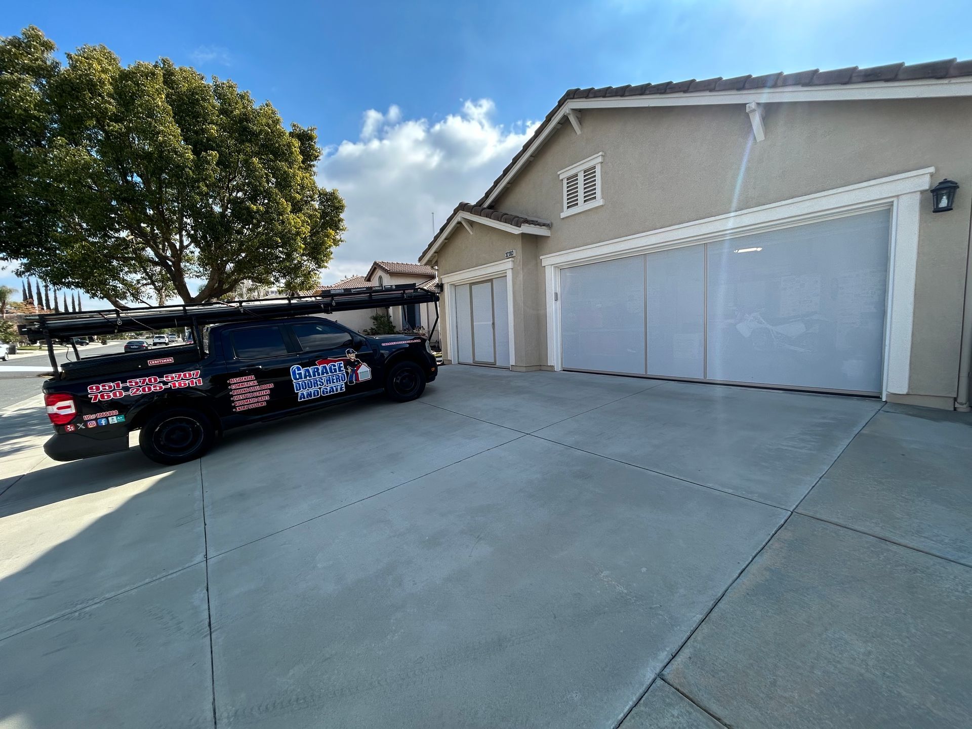 A black truck is parked in a driveway in front of a house.