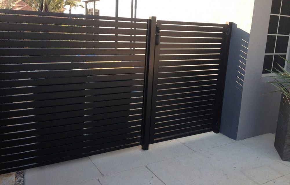 A black fence with a gate in front of a building