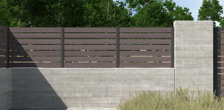 Valla Dlimity Nature 020. Sin mantenimiento. Valla con lamas de madera sintética (WPC) color Nogal separadas 2 cm y postes de aluminio. Valla abierta para jardin, casa, finca, separacion de ambientes. 5 años de garantia. Fabricacion a medida, entrega en kit.