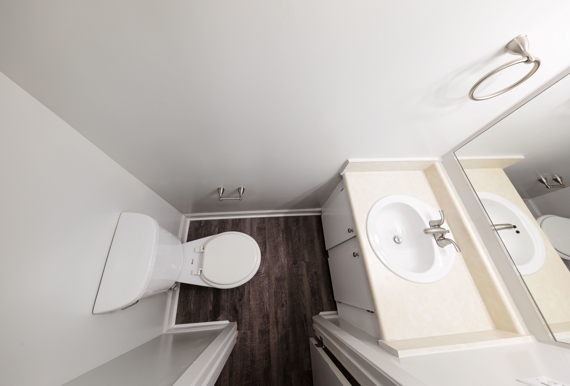 Apartment bathroom with toilet, sink, and vanity.