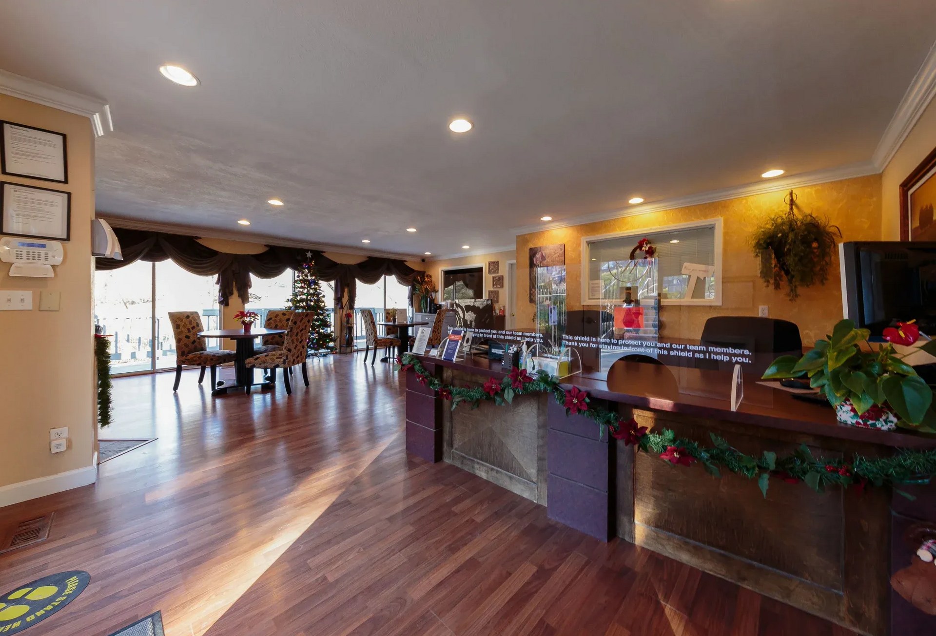 Apartment community lobby with front desk, seating area, and festive holiday decor.