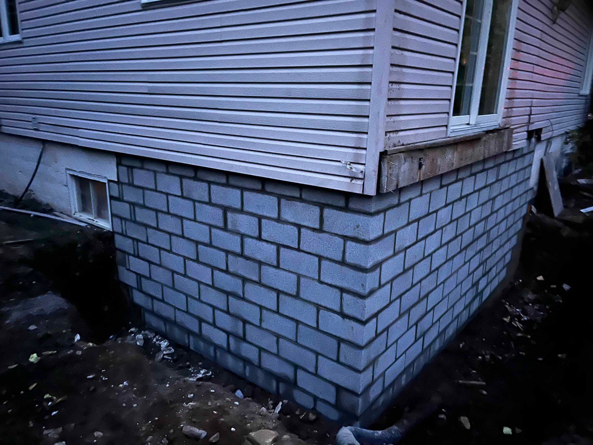 Un mur de briques est en construction sur le côté d'une maison