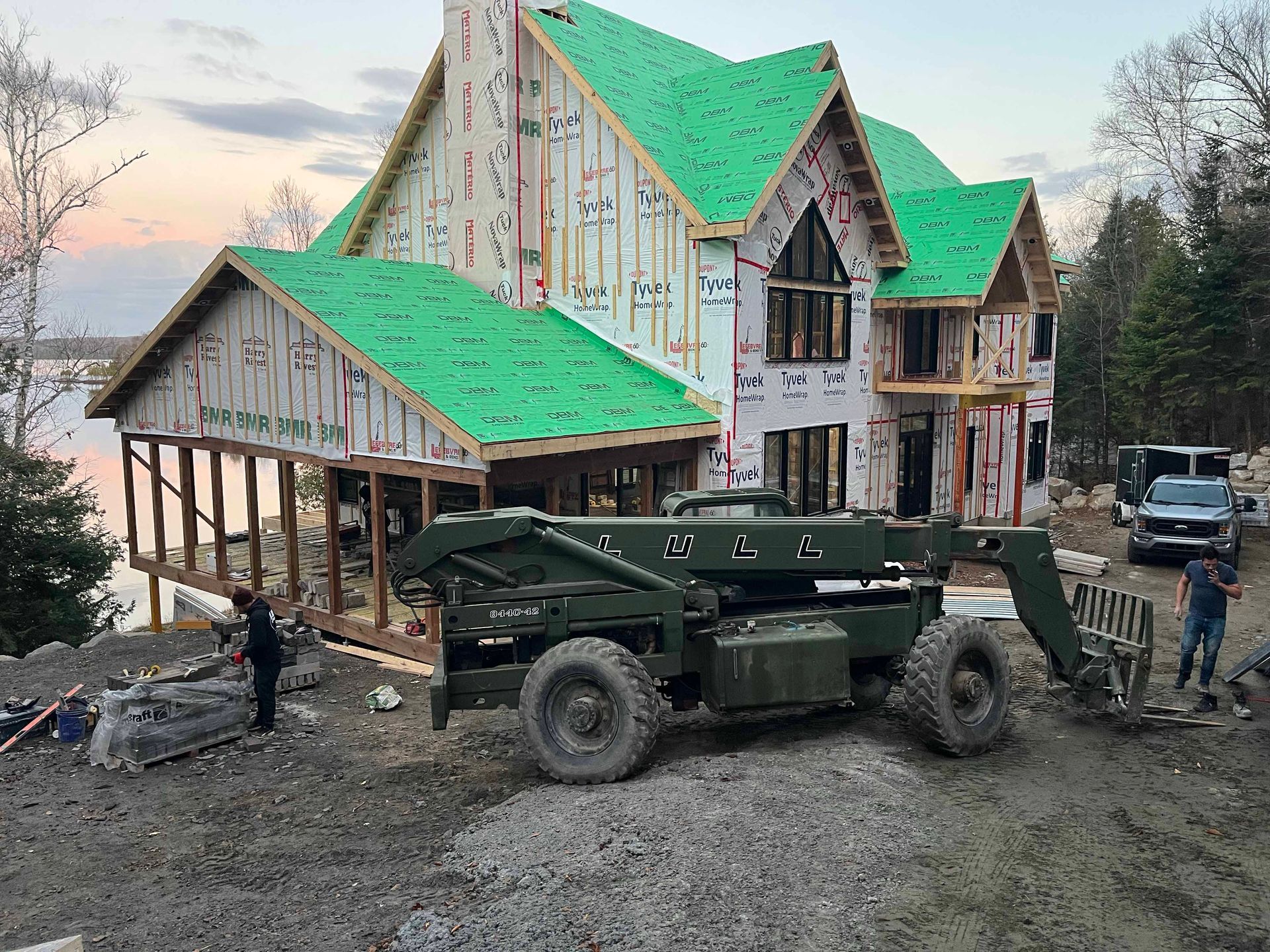 Une grande maison est en construction avec un toit vert.