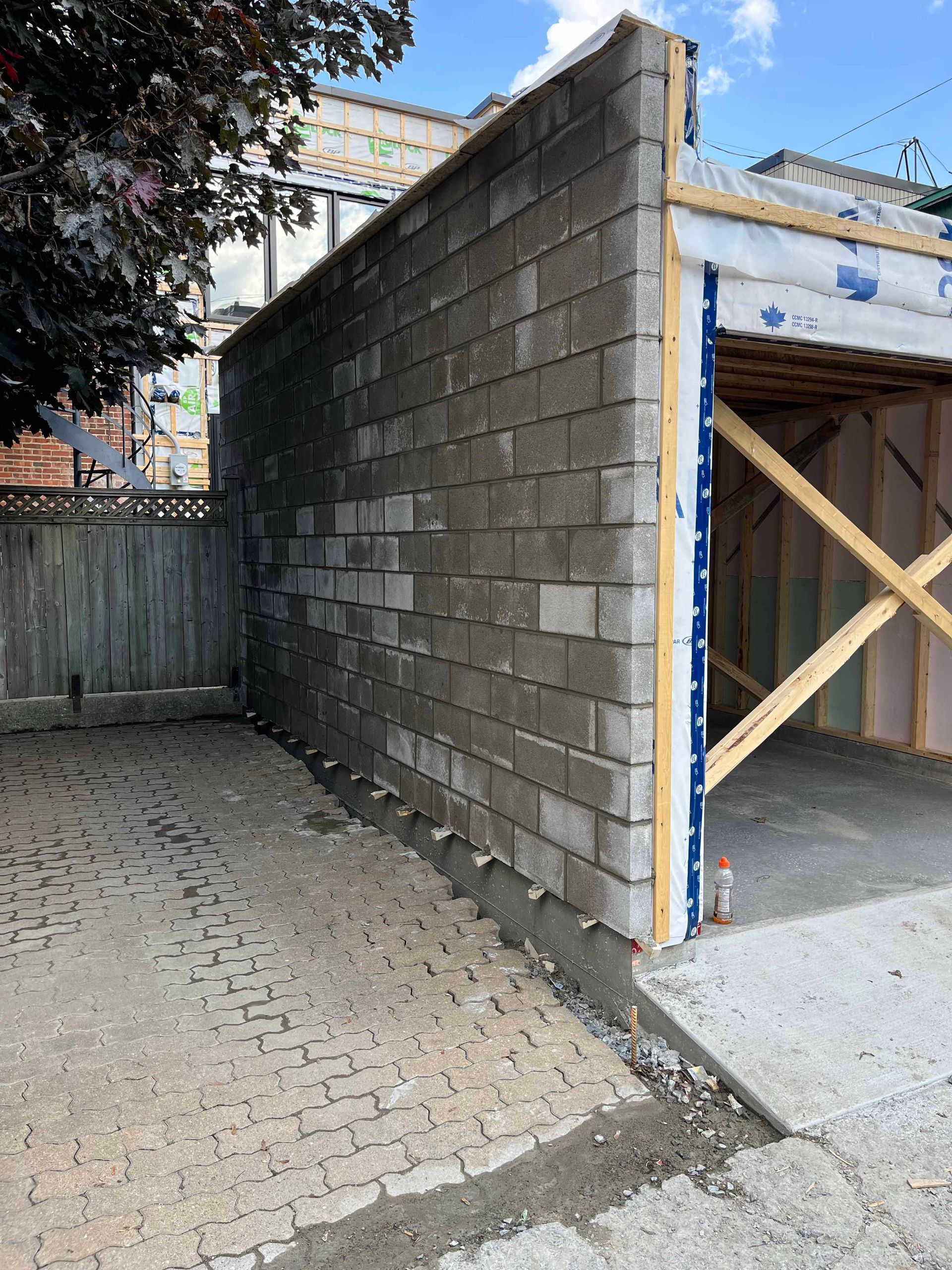 Un garage est en cours de construction avec des briques et du bois.