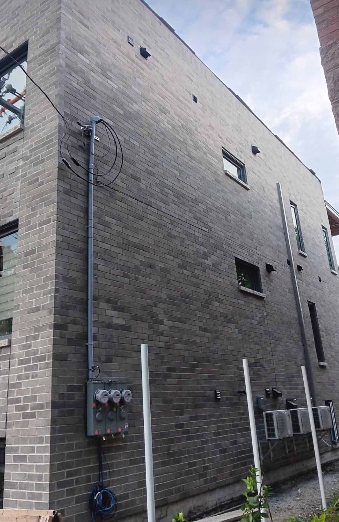 Un grand bâtiment en briques avec beaucoup de fenêtres est en cours de construction.