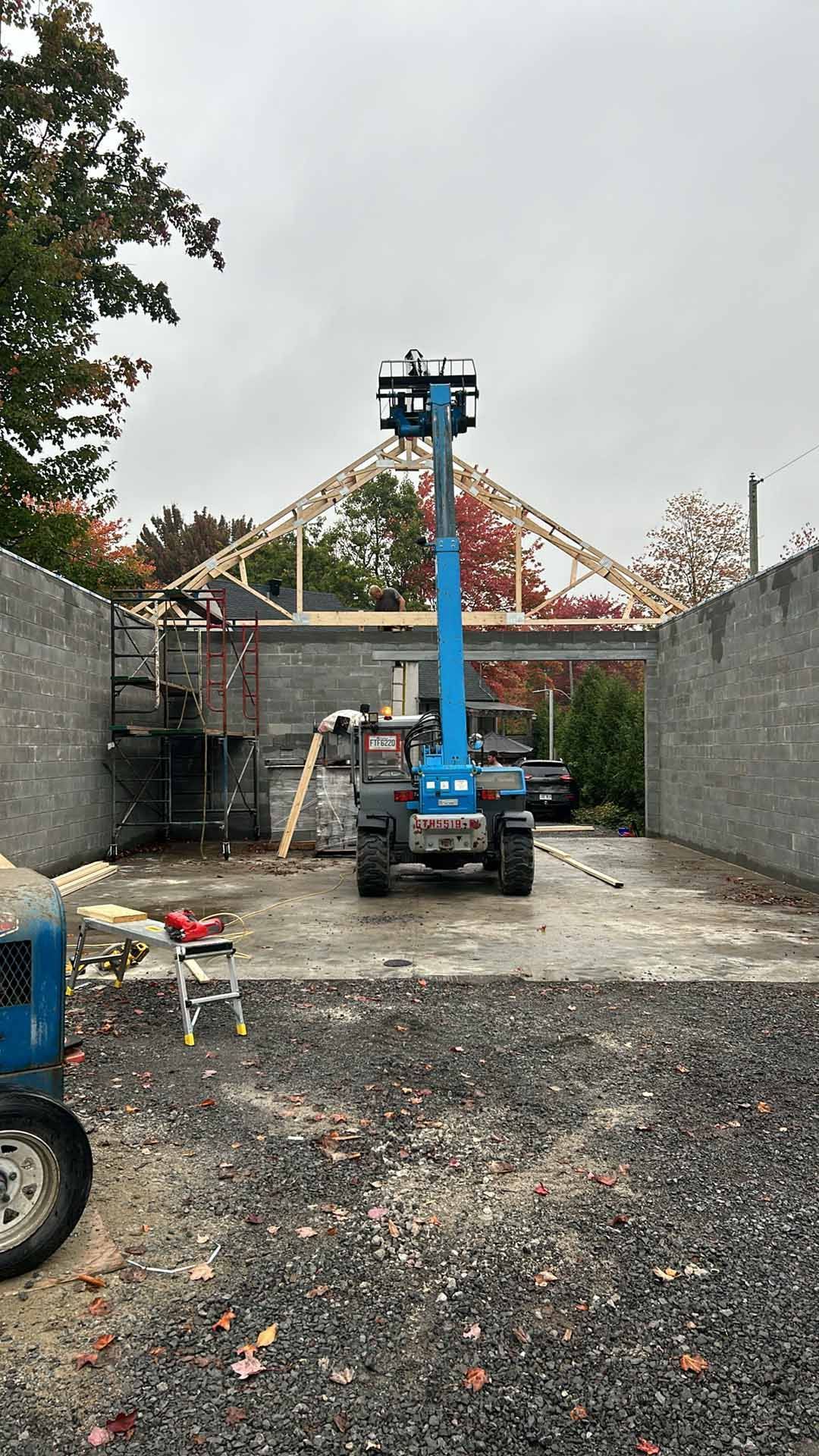 Une grue est assise sur un parking à côté d'un bâtiment en construction.