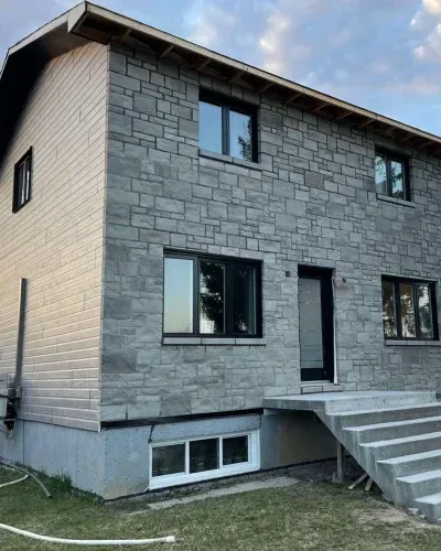 Une grande maison en briques avec des escaliers qui y mènent.