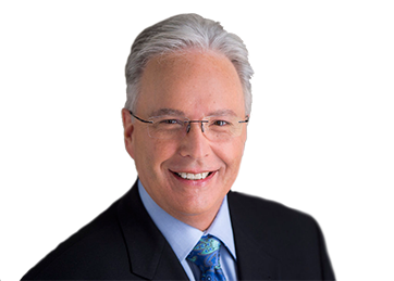 Smiling man in a suit and tie with glasses.