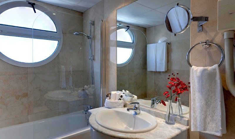 Un baño con lavabo, espejo y bañera.
