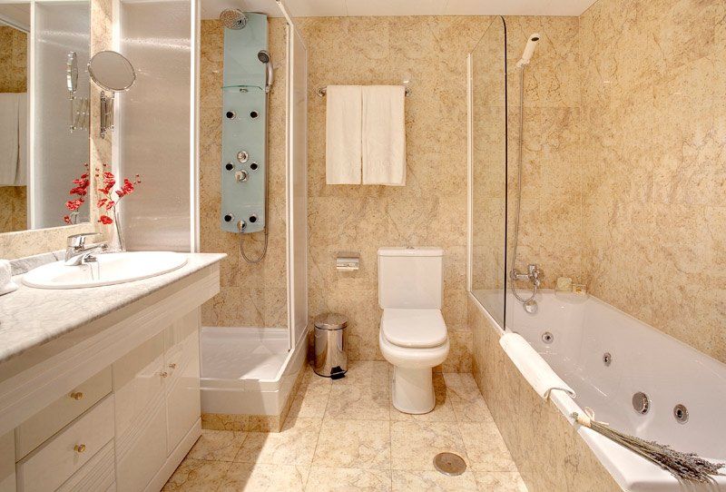 Un baño con bañera, inodoro, lavabo y ducha.