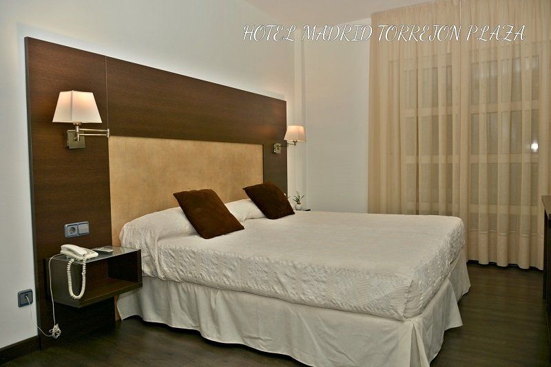 Una habitación de hotel con una cama tamaño king y dos mesitas de noche.